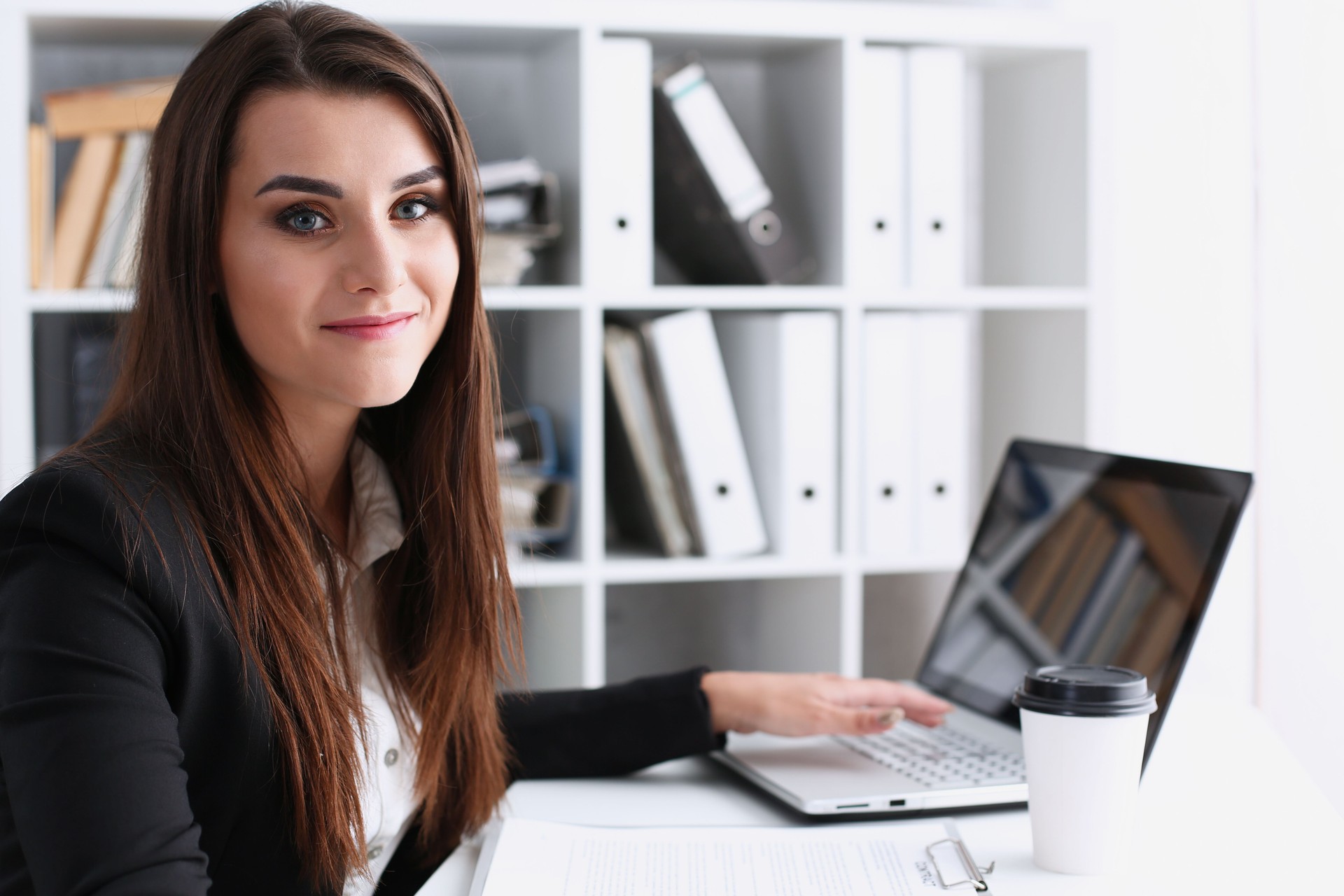 Empresaria en la oficina tiene su mano en la computadora portátil